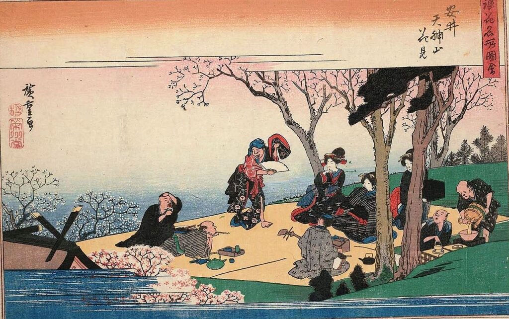 Hanami in Osaka. People enjoy viewing blossoms with dance, music, food and sake. The black box on the right is a multi-tiered bento box. Hiroshige (1834)