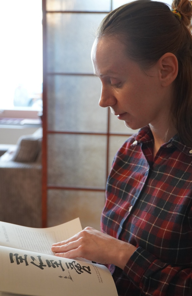 Kristina reading Journey to the Heart of Aikido by Linda Holiday sensei